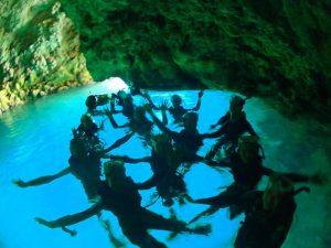 青の洞窟シュノーケリングで洞窟内を貸し切りで写真撮影する団体大学生